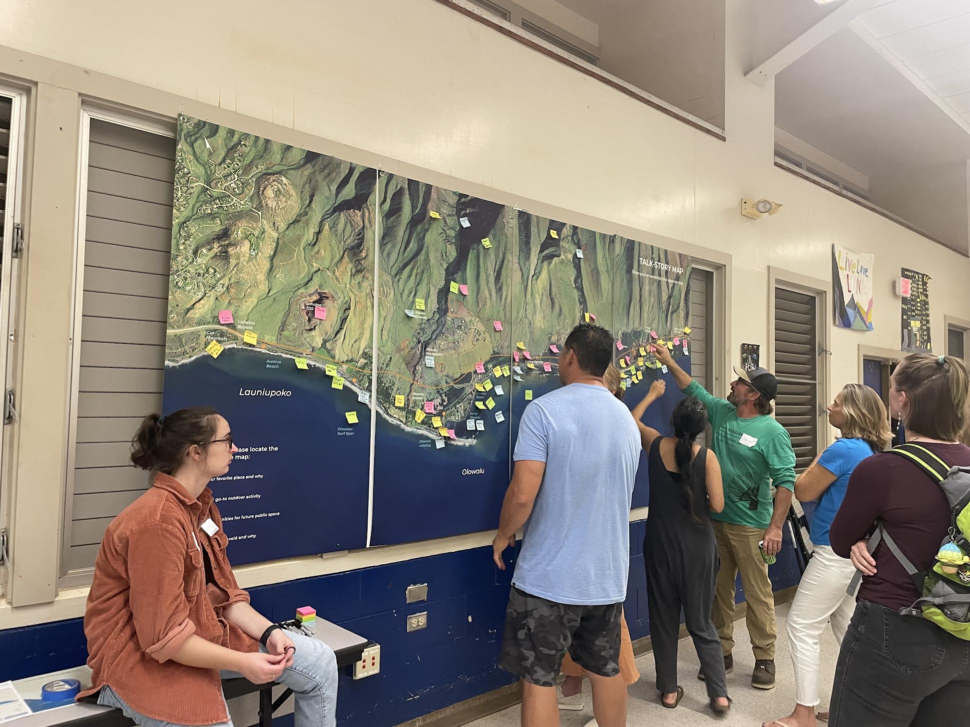 People standing in front of a map with marks. 